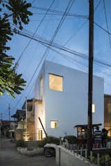 Exterior, House Building Type, Brick Siding Material, Flat RoofLine, and Concrete Siding Material Windows of varying sizes punctuate the building, giving it a sculptural appearance.   Photo 2 of 12 in This Skinny, Minimalist Home Gets a Modern Revamp For $20K