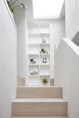 The stairs, built of white-stained engineered oak, connect the lower-level living area with the kitchen and bedrooms. 
