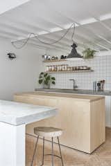 Bert & May Terracotta Arcilla handmade tiles line the kitchen floor and are complemented by cabinets with IKEA carcasses and white-sprayed MDF doors. There is also a cast in-situ concrete counter, which can be used as a secondary dining area or breakfast bar.

