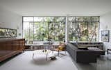 Living Room, Sofa, Laminate Floor, Storage, Chair, and Coffee Tables The original steel window frames were restored and now overlook views of a lush canopy.

  Photo 3 of 12 in window by Molly E. Osler, Interior Design from Greenery Breathes Fresh Life Into a Brazilian Midcentury