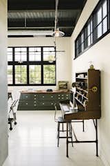 Office, Library Room Type, Chair, Desk, Painted Wood Floor, and Storage A vintage post office desk anchors one end of the office that's fitted with built-in cabinetry with a 16-foot-long walnut top on the far wall.  Photos from A 1920s Portland Warehouse Is Rehabbed Into an Industrial-Chic Home