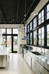 Stainless steel has been used for the kitchen counters, cabinets, and backsplash.