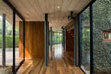 Topped with a thin slab of board-formed concrete, the glazed corridor doubles as the entry foyer.