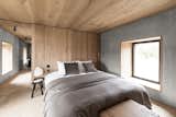 Bedroom, Medium Hardwood Floor, Night Stands, Bed, and Floor Lighting The bedroom is the most pared-back room in the house with just a handful of furnishings including a custom-designed bed.  Photos from Cozy Up in a Nordic-Inspired Retreat Reborn From Ruins