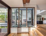 A glimpse of the kitchen as seen from the dining room. Tallowwood floorboards (Bona Traffic) have been used throughout.  Photo 7 of 17 in Water Slices Through This Gorge-Inspired Australian House