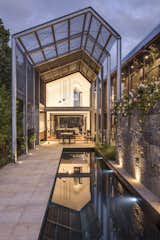 Outdoor, Large Pools, Tubs, Shower, Back Yard, Large Patio, Porch, Deck, Stone Patio, Porch, Deck, and Stone Fences, Wall A linear swimming pool in the back of the property runs parallel to the central axis.   Photos from Water Slices Through This Gorge-Inspired Australian House
