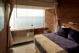 Bedroom, Bed, Concrete, and Travertine All four bedrooms overlook the Pacific Ocean.

  Bedroom Travertine Photos from A Sculptural Holiday Home is Shaped by the Peruvian Desert