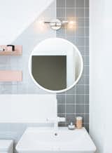 Bath Room, Two Piece Toilet, Porcelain Tile Floor, Wall Mount Sink, Wall Lighting, and Ceramic Tile Wall The sink is from Duravit.  Photos from Budget Breakdown: A Humdrum Bathroom Gets a Retro-Chic Facelift For $17K