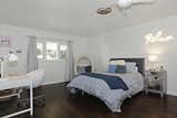 Bedroom, Dark Hardwood, Bed, Night Stands, Chair, Lamps, Ceiling, and Table The former master bedroom was turned into a room for Carolla's daughter.   Bedroom Dark Hardwood Chair Ceiling Bed Photos from Own Comedian Adam Carolla’s Renovated L.A. Midcentury For $3.4M