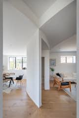 Living Room, Coffee Tables, Sofa, Chair, Medium Hardwood Floor, Recessed Lighting, and Table A powder room is sandwiched between the dining room and den.

  Photos from Stacked Boxes Form an Experimental Hillside House