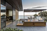 The outdoor terrace is paved with honed basaltina. The teak outdoor sofas arranged around the fire pit are by James Perse.