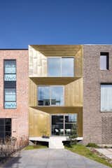 Exterior, House Building Type, Flat RoofLine, and Metal Siding Material Sandwiched between two brick-clad homes, the Brass House on Haveneiland-Oost catches the eye with its angled brass facade that changes color from gold to brown in the light.  Photos from A Sculptural Brass House Glows Like a Jewel in Amsterdam