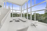 Living Room, Sectional, Chair, Recessed Lighting, Limestone Floor, and Coffee Tables The dramatic, double-height great room in the Shamberg House is surrounded by walls of glass to overlook woodland views.  Photos