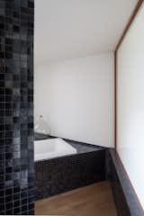 A peek inside a mosaic-tiled bathroom with a soaking tub.