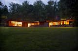 Exterior, House Building Type, Wood Siding Material, Flat RoofLine, Brick Siding Material, and Glass Siding Material A nighttime view of the home seen from the northeast. To the right is the bedroom wing extending north. To the left is the living room wing stretching to the east.  Photo 8 of 12 in New Jersey’s Oldest and Largest Frank Lloyd Wright House Cuts Price to $1.45M
