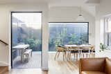 Dining Room, Pendant Lighting, Chair, Medium Hardwood Floor, and Table Large walls of glass let plenty of natural light and views into the expanded home.  Photo 9 of 16 in An Art Deco Dwelling Receives a Sleek, Contemporary Extension