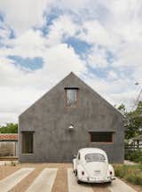 The home's simple gabled shape is emphasized by the use of burnished stucco on all sides. 