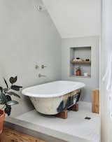 The clawfoot tub was a salvaged find, while reclaimed wood was used for the shelving. 