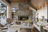 Living Room, Wood Burning Fireplace, Chair, Wall Lighting, Medium Hardwood Floor, Coffee Tables, Sofa, and Recessed Lighting The Great Room is anchored by a large granite fireplace crafted by James Hamblin, using locally quarried granite veneer.

  Photos from This Modern Cliff House Seamlessly Knits Into a Rocky Idaho Lakefront