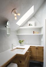 Bath, Undermount, Dark Hardwood, Laminate, Wall, and Concrete The operable bath skylight is from Vellux. The floors are porcelain tile and the counters are laminate with longleaf pine edge.   Bath Dark Hardwood Wall Photos from A Whimsical Guest House Leans Out to Maximize Space