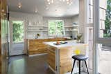 The compact kitchen features plenty of counter space. The cabinet fronts are made from reclaimed longleaf pine sheathing from a local bungalow.