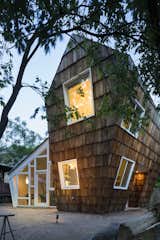 Shingles, Exterior, Exterior, House, Wood, Gable, and Shed Built for television and documentary film producer Kerthy Fix, The Hive is located behind the client’s main residence in East Austin.   Exterior Wood Gable Shingles Shed Photos from A Whimsical Guest House Leans Out to Maximize Space