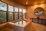 Bath Room, Pendant Lighting, Vessel Sink, Wood Counter, Concrete Floor, Concrete Wall, Recessed Lighting, and Soaking Tub The custom concrete soaking tub is set in front of a wall of windows.   Photo 12 of 15 in Escape to the Texan Treetops in This Eco-Luxe Treehouse