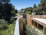 The massive curving wall serves as an alternative to the perimeter fence that's common to the neighborhood, an area which the architects says has developed a hodgepodge of architectural styles. 