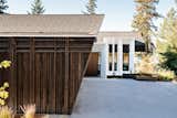 The roof is sheathed in asphalt shingles and is complemented by charred timber siding. 