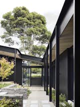 "Three elongated blackened timber pavilions form a U shape, encompassing the external courtyard and identifying strongly with the site narrative and notions of a working yard or arena," the architects explain.
