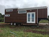 Exterior, Tiny Home, Metal, Wood, Beach House, Shed, and Flat Tongue-and-groove cedar siding clads the exterior. The windows are by Alpine.  Exterior Flat Wood Beach House Tiny Home Photos from Budget Breakdown: A Maui Couple Build an Off-Grid Tiny Home For $45K