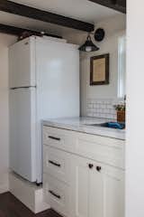 Kitchen, Drop In, Medium Hardwood, White, Refrigerator, Subway Tile, Laminate, and Wall A Vissiani refrigerator stands next to the kitchen's formica countertops. The lights are from Ecopower.   Kitchen Wall Subway Tile Photos from Budget Breakdown: A Maui Couple Build an Off-Grid Tiny Home For $45K
