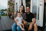 Outdoor, Large, Grass, Decking, Back Yard, and Hanging Zeena, Shane, and their one-year-old son, Maverick, on the porch of their tiny house.   Outdoor Decking Grass Back Yard Hanging Photos from Budget Breakdown: A Maui Couple Build an Off-Grid Tiny Home For $45K