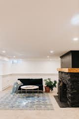 The updated basement is much brighter thanks to new paint, carpets from Lowes, and new lighting. The fireplace was painted Dark Kettle Black by Valspar.