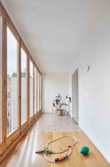 Lined with glazed folding doors that open up to a balcony, this light-filled corridor next to the living areas provides indoor/outdoor living. 