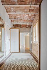 "We proposed a few interventions of wood placed on the floor without breaking the flow of the mosaic and never rising all the way up," the architects note. "This way, all the quirks, turns and bulk of Catalan-style ceilings would remain visible to cover the length of the new distribution."