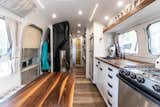 A view from the front of the Airstream towards the angled bathroom door in the rear. Note the small closet, perfect for hanging coats and boots, slotted between the door and the wood stove. 