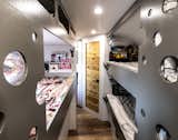 The "kids' area" in the heart of the Airstream features three bunk beds fitted with twin-size IKEA foam mattresses, built-in storage, and  privacy curtains. The round cutouts reference the Airstream's rounded shape and the portholes in ships. 