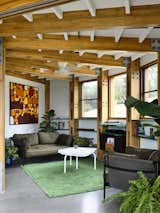 The cozy living room pulls the outdoors in with its earthy palette and abundance of indoor greenery. 