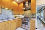 The backsplash and countertops are made from granite. Terrazzo marble lines the kitchen floor.