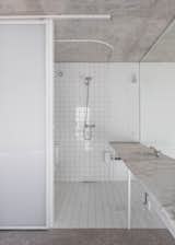 10cm x 10cm white tiles line all the bathroom walls and floors. The same tiles pop up in the kitchen.