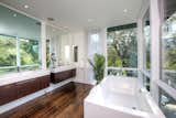The master bath includes double vanities, a freestanding bathtub, and a hidden built-in television.