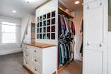 The master walk-in closet includes custom cabinets and a washer/dryer with a folding surface.