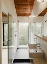 The guest bathroom features a full-height window with immersive canopy views.