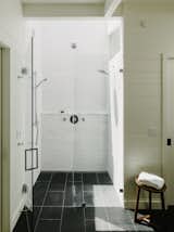 White ceramic Fireclay tile wraps around the shower. Skylights bathe the master bath in natural light.