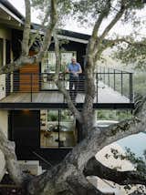 Malcolm Davis stands behind the specimen oak tree on the new cantilevered wraparound deck.