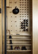 The multifunctional organizer at the entry includes an umbrella stand, a shoe rack, and an adjustable pegboard that serves as a wine rack and hat/helmet rack.