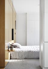 Bathed in light from the rising sun, the bedroom includes a wall of built-in closets. The nightstand is a fold-down wall panel.