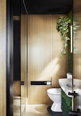 "I really enjoy the bathroom space, as the apartment doesn’t have an outdoor space so I tried to create the illusion of green outdoor environment in the bathroom, with the green moss wall, timber tiles, etc.," says Chen. The bathroom, seen here from the bedroom, also has a retractable clothesline.