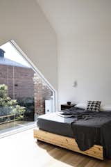 Bathed in west-facing light, the master bedroom includes a large window (also created in the shape of the roof) with views of the rear garden. 